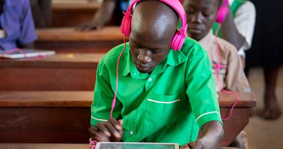 Boy with pink headphones receiving quality education in a class with Can't Wait to Learn Uganda_War Child_180606