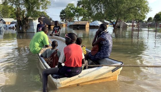 People in a boat going to the flooded houses after heavy rains in South Sudan_War Child_201107